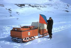 Tracked experimental snow mobile. Richard Moskal holding the flag of the, "Geographical Bran...